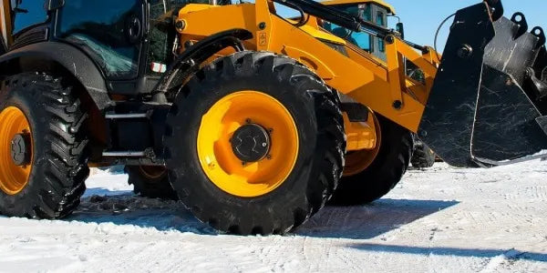 Żółta ładowarka kołowa JCB na zaśnieżonym placu