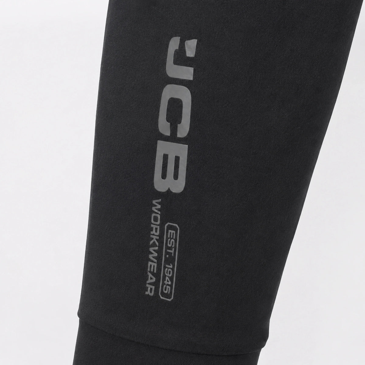 Zbliżenie na logo JCB Workwear na spodniach termoaktywnych czarnych