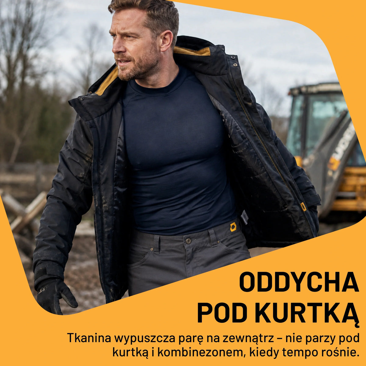 Mężczyzna w granatowej koszulce termoaktywnej JCB pod kurtką na budowie, tekst Oddycha pod kurtką