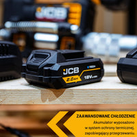 akumulator li-ion JCB 18V 2.0Ah na desce w warsztacie z tekstem zaawansowane chłodzenie i ochrona termiczna