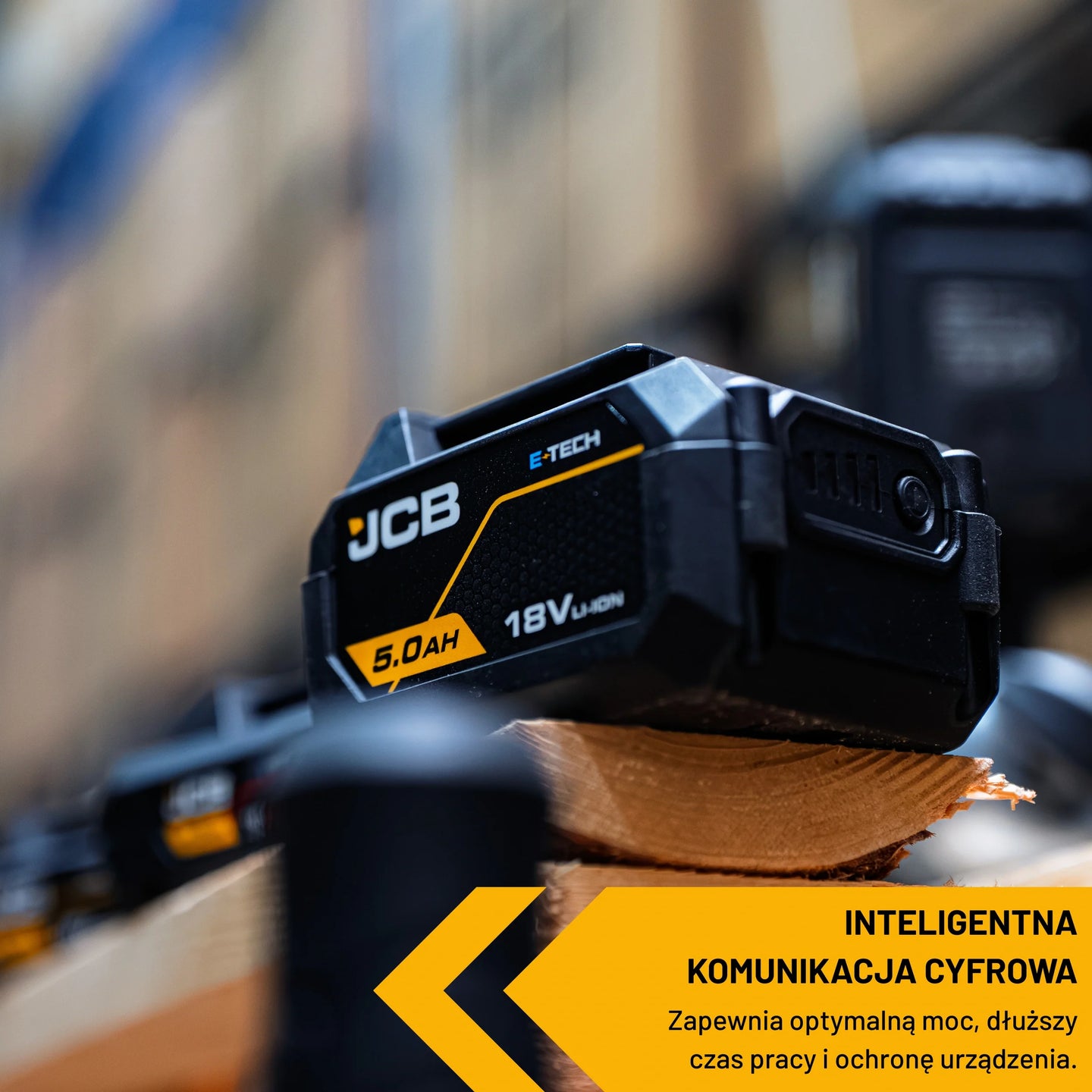 akumulator li-ion JCB E-Tech 18V 5.0Ah na desce w warsztacie ujęcie z góry z tekstem inteligentna komunikacja cyfrowa