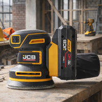 szlifierka mimośrodowa JCB Professional 18V z akumulatorem E-Tech HC 4.0Ah na stole warsztatowym w tle plac budowy