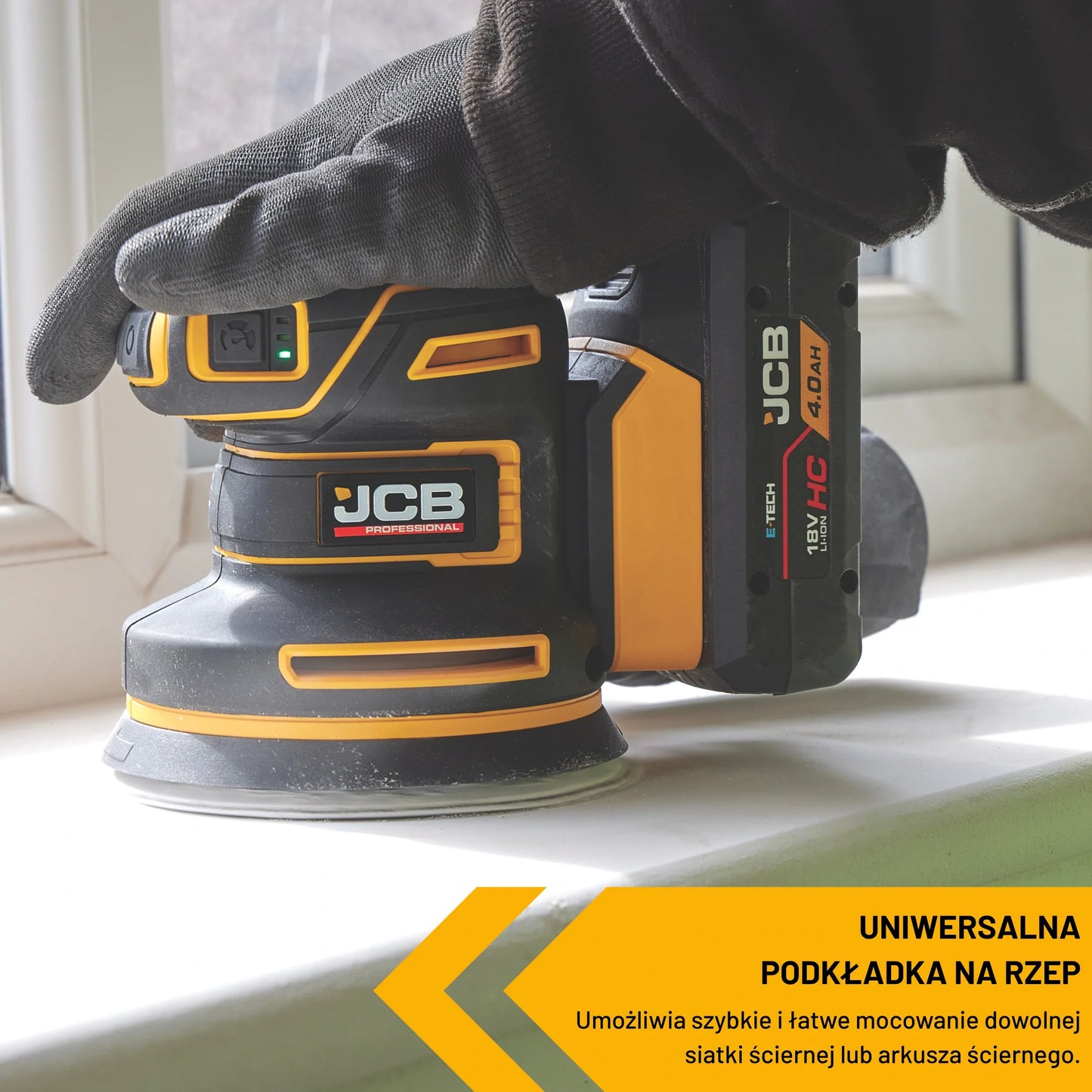 szlifierka mimośrodowa JCB Professional 18V z akumulatorem HC 4.0Ah podczas szlifowania parapetu ujęcie z bliska z tekstem Uniwersalna podkładka na rzep