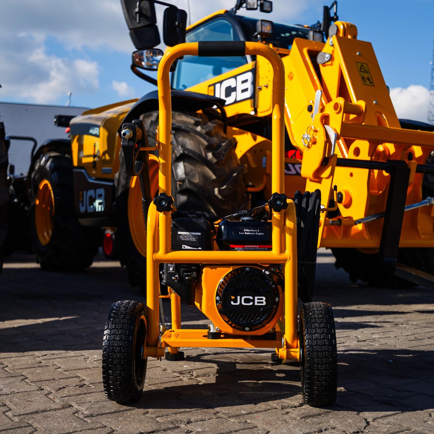 Myjka ciśnieniowa JCB PW15040PP24 ujęcie od tyłu silnik z logo JCB wentylator czarne koła i żółta stalowa rama