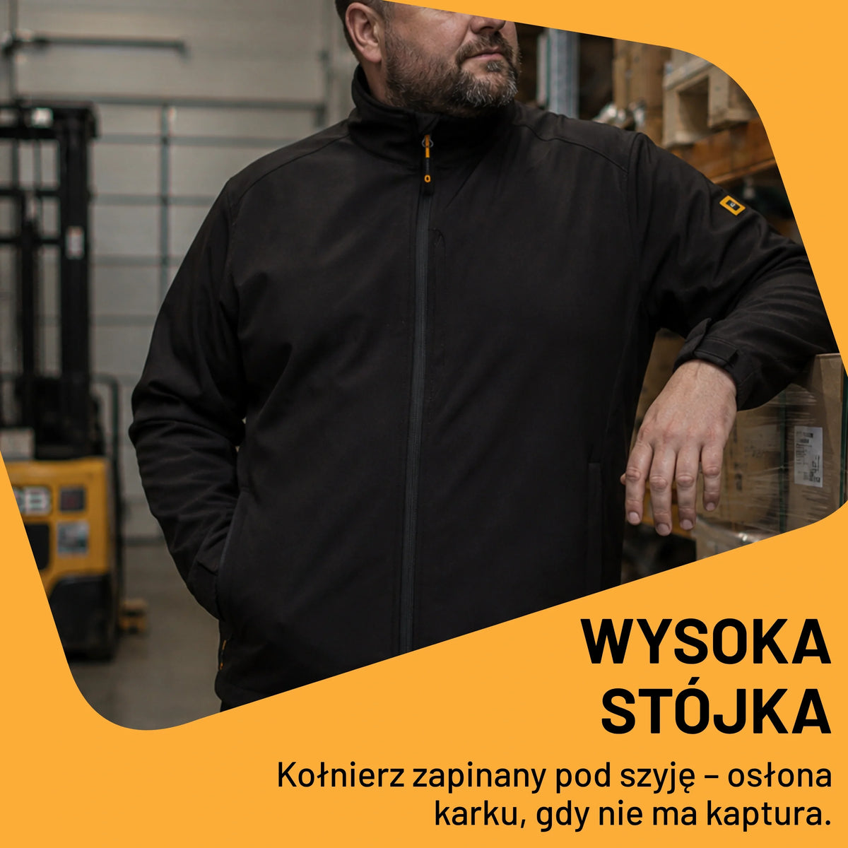 Mężczyzna w czarnej kurtce roboczej softshell JCB w warsztacie, tekst Wysoka stójka