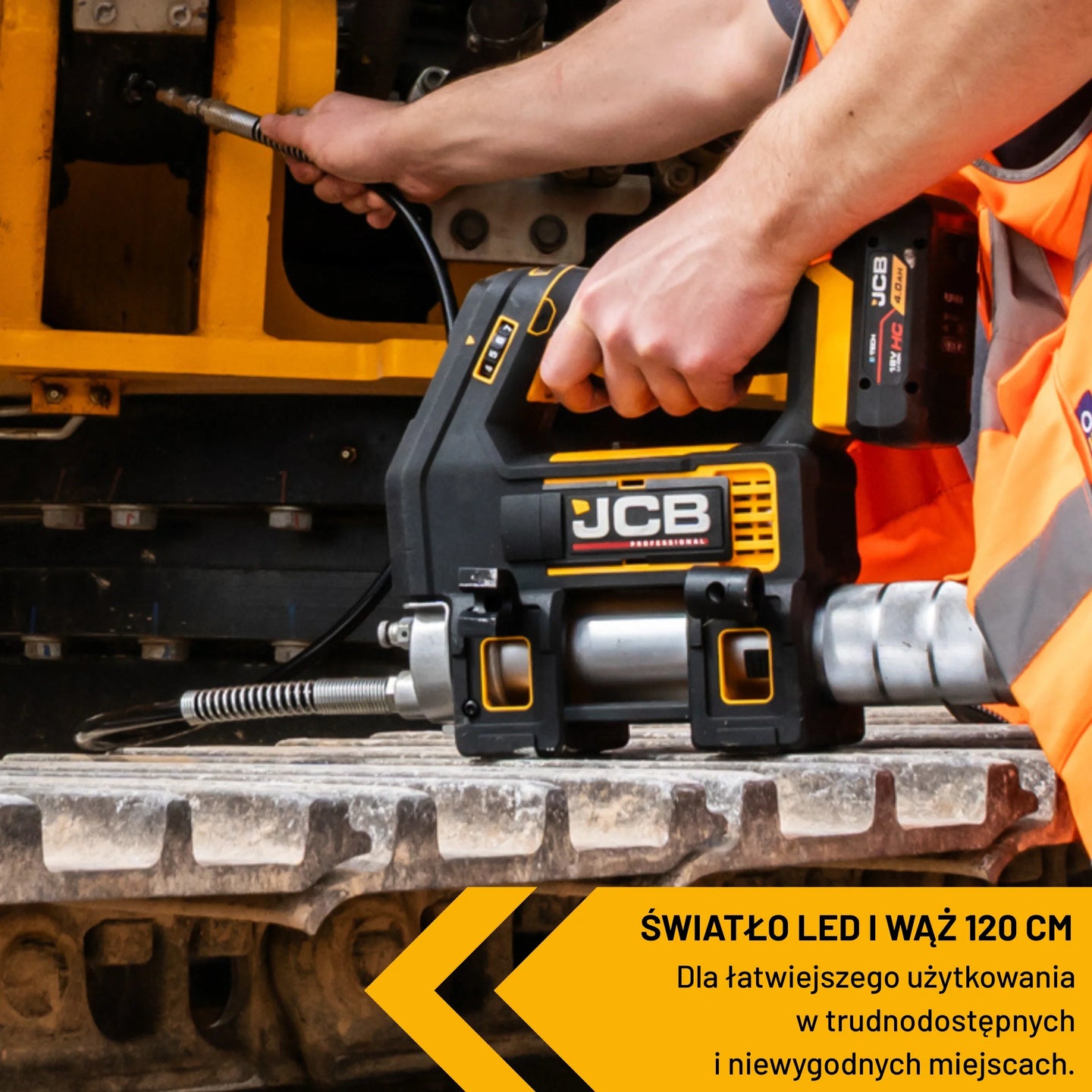 Pracownik w kamizelce odblaskowej smarujący gąsienicę maszyny tawotnicą akumulatorową JCB 18PGG-zestaw-1 światło LED i wąż 120 cm