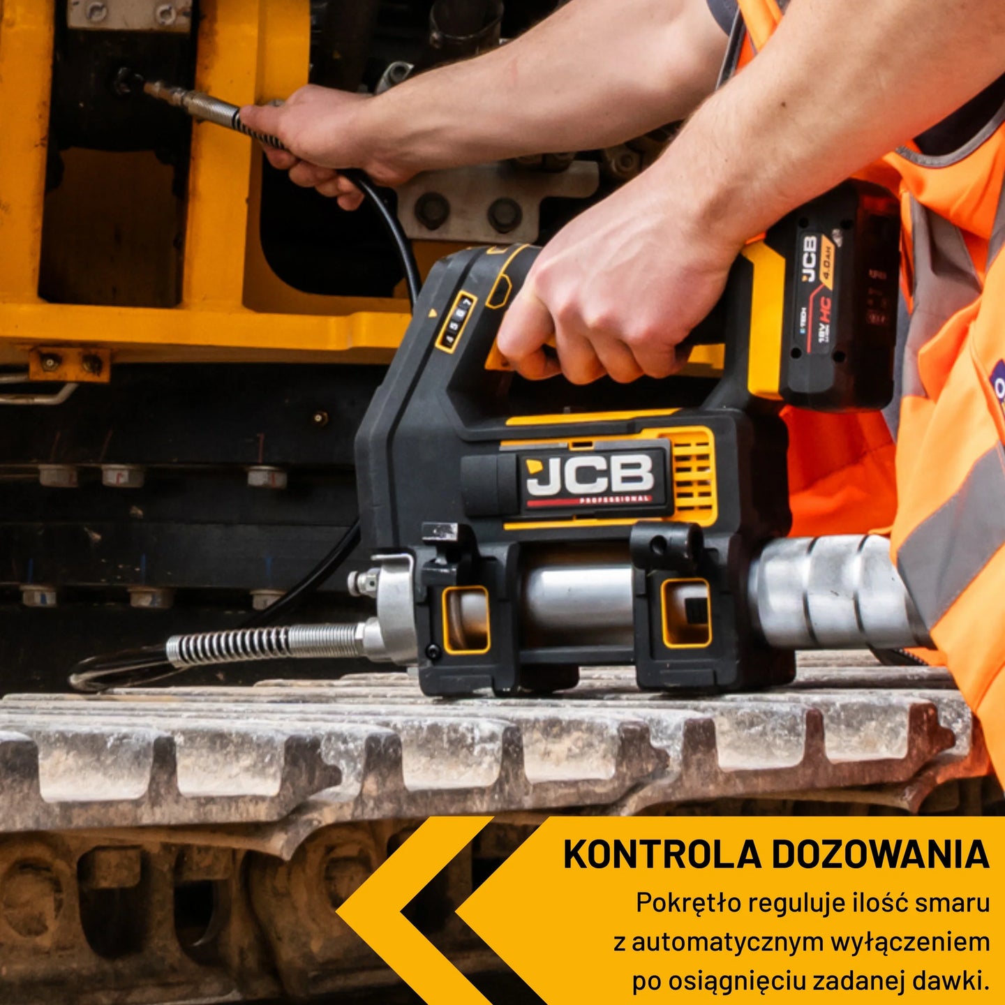 Smarownica akumulatorowa JCB 18V z zestawu JCB-18PKIT-5 trzymana w dłoniach nad gąsienicą maszyny napis Kontrola Dozowania